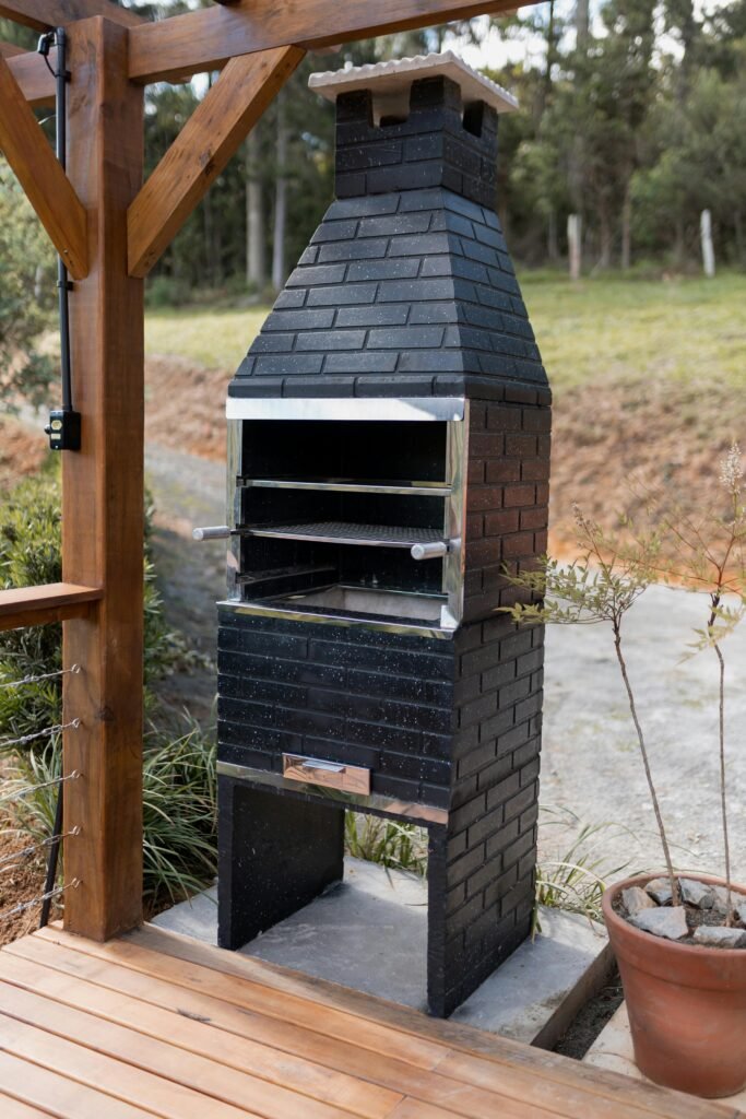 Black brick barbecue grill on a patio deck, ideal for outdoor cooking.