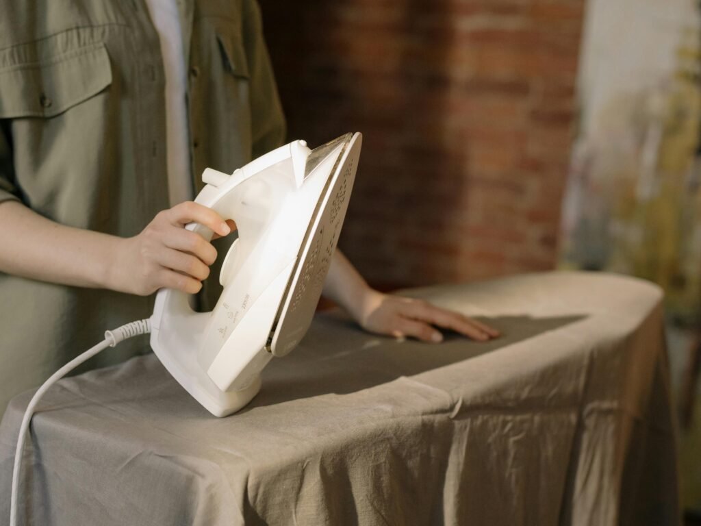 Close-up of a person ironing clothes, showcasing household chores in a home setting.