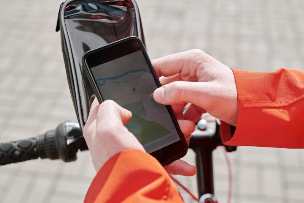 Close-up of cyclist using a smartphone GPS navigation app on a bike mount outdoors.