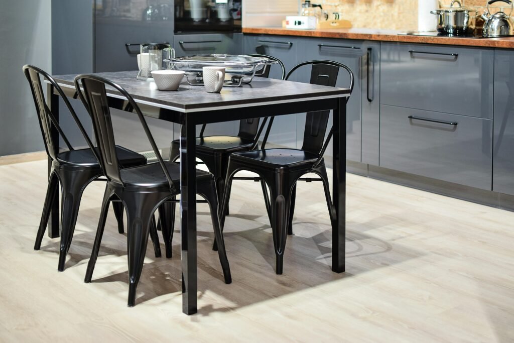 Stylish modern kitchen featuring a black metal dining table with chairs and sleek cabinetry.